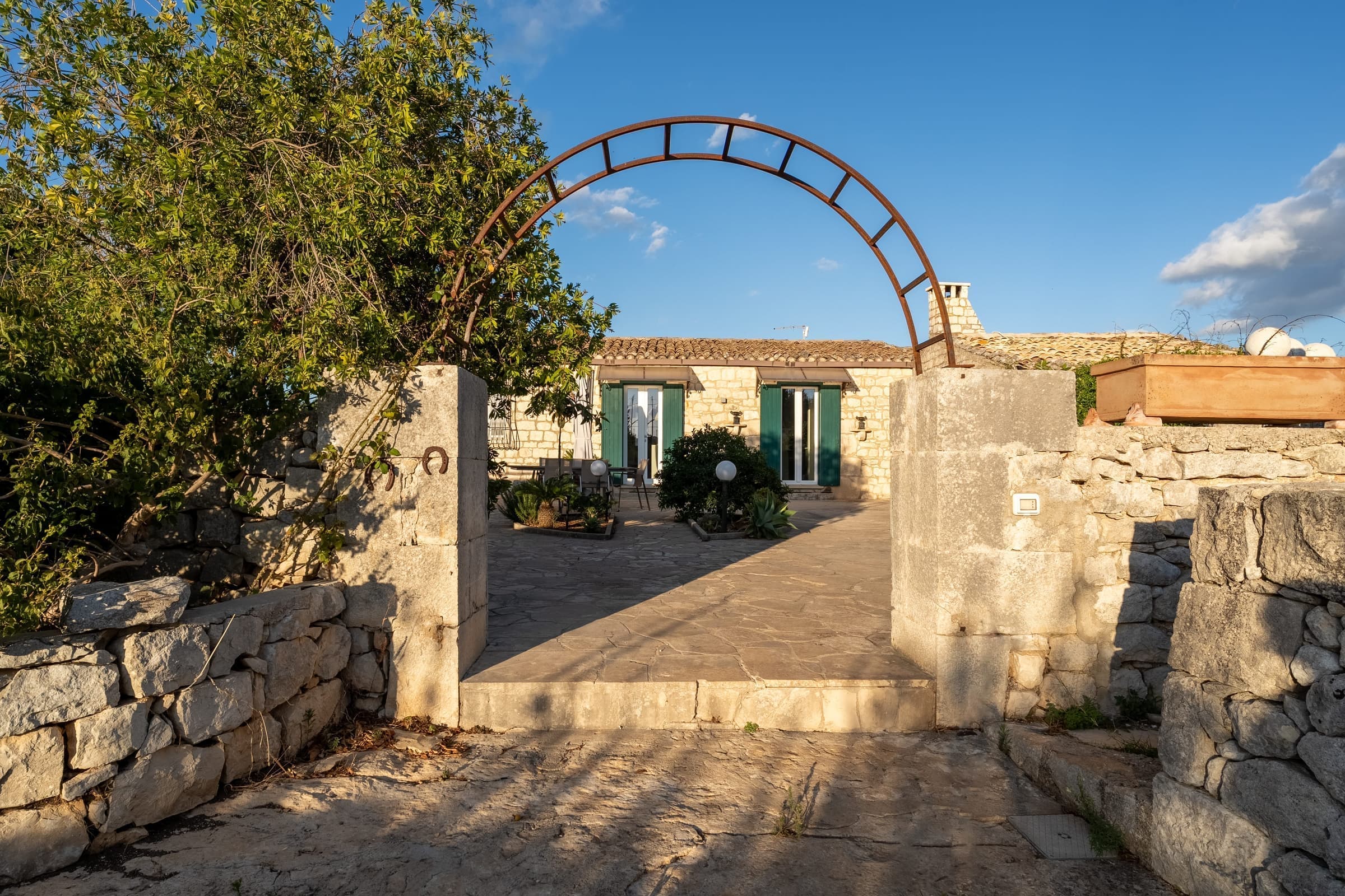 Stone archway entrance with lush gardens